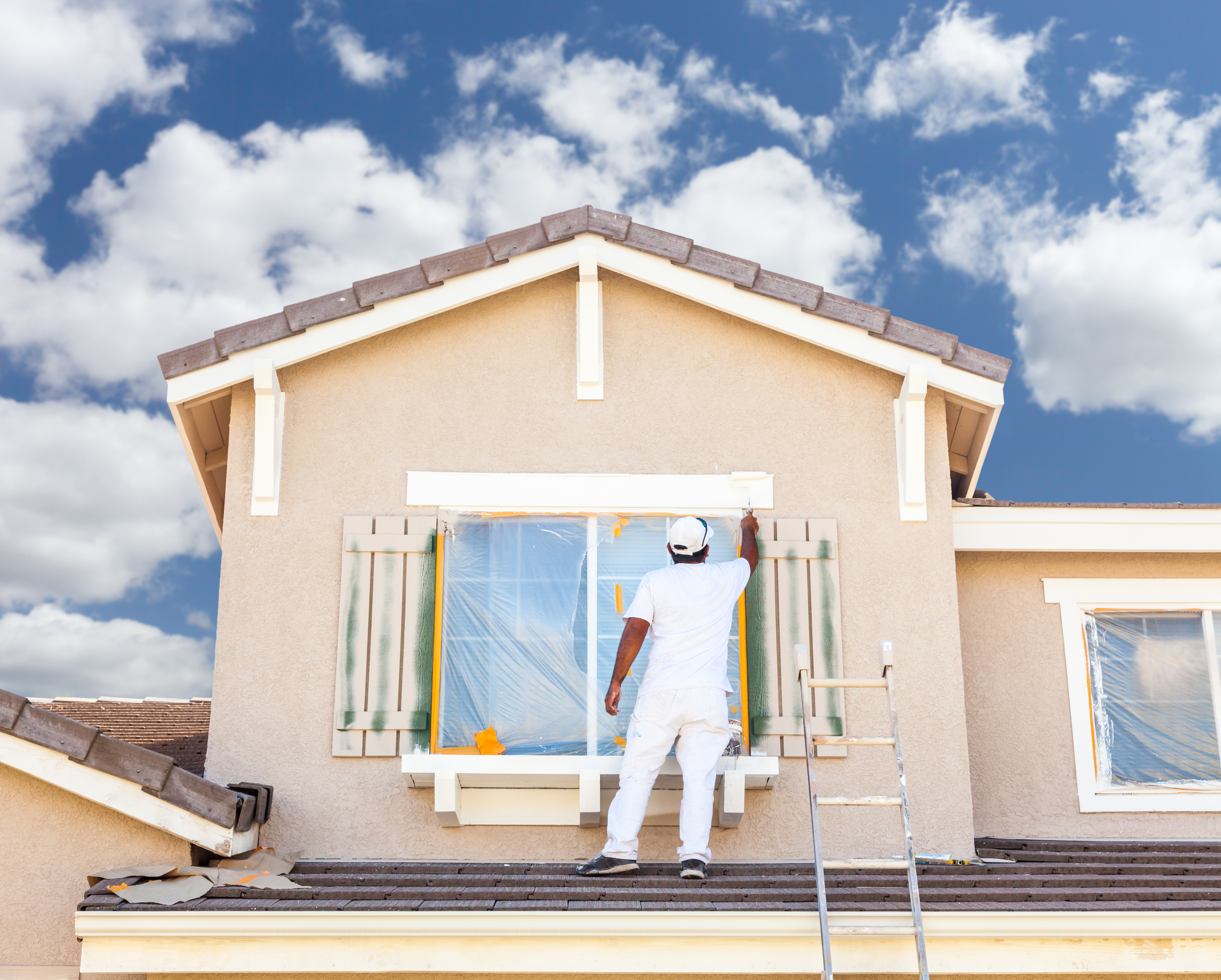 A man painting the exterior of a house 